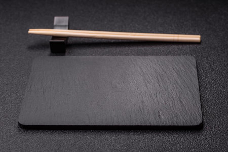 An empty slate cutting board with cutlery on a kitchen counter. Slate cutting board, food background for your designの写真素材