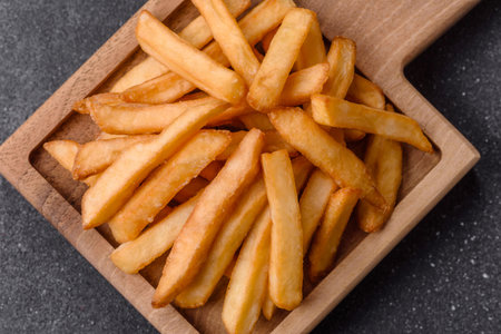 French fries, a salty, crispy, homemade snack with spices. French fries as a food background for...