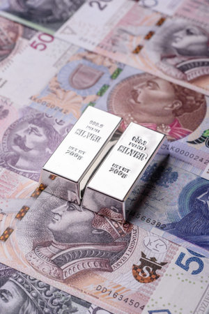 A silver bar, white metal against a backdrop of Polish flag, as a concept for the sales market. A...