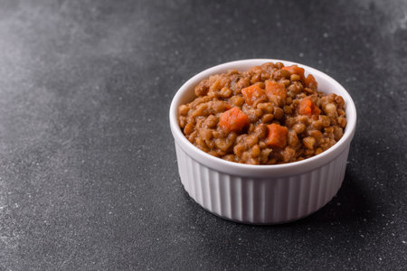 Lentil, carrot, and tomato stew, a European dish. Lentils with sausages as a food background for your designの写真素材