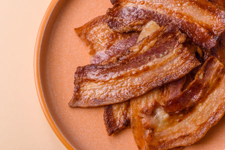 Fried fresh bacon slices with layers of meat or prosciutto prepared for breakfast. Fried bacon as a food background for your design