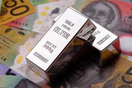 A silver bar, white metal against a backdrop of various currencies, as a concept for the sales market. A silver bar as a background for your design