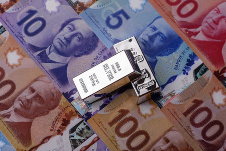 A silver bar, white metal against a backdrop of Canadian money, as a concept for the sales market. A silver bar as a background for your design