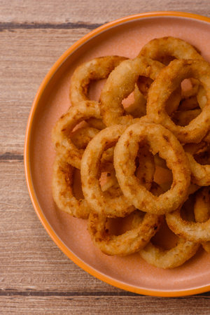 Deep fried breaded onion or squid rings, crispy fast food snacks. Fried onion or squid rings as a food background for your design.