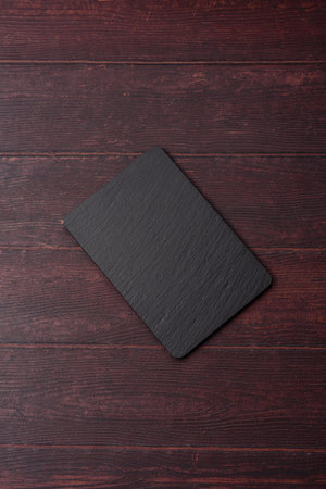 An empty black slate kitchen board for food preparation. An empty slate board serving as a food background for your design