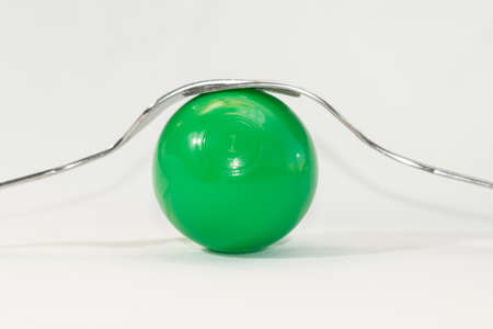 abstract still life, two forks and colored balls on a white background