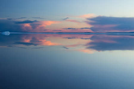 Melting spring mountain lake in the setting sun.の写真素材