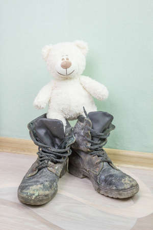 Children's toy and old army boots.の写真素材