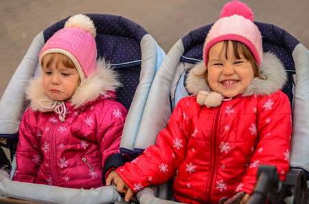 two little girls, sisters. One cries, other laughsの写真素材