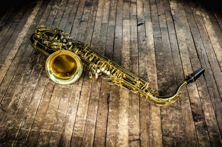 golden saxophone wind instrument on wooden brown stageの素材 [FY310145101855]