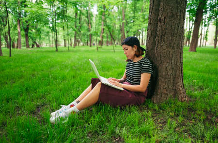 young girl teenager in casual clothes and snapback baseball cap peaks back, a striped T-shirt and a...