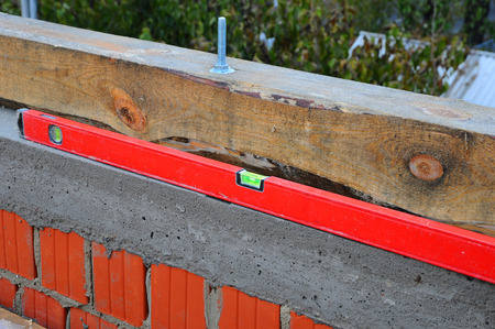 Checking the level of brick masonry. Spirit level on bricks. Smooth seams masonry roof