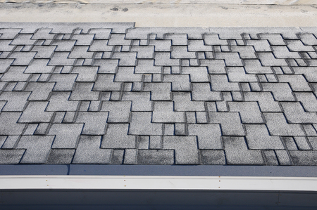 Close up view on unfinished Asphalt Roofing Shingles Background. Unfinished Roof Shingles - Roofing. Roof shingles covered with frostの写真素材