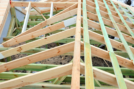 Installation of wooden beams at the construction of the truss system of the house. New unfinished...