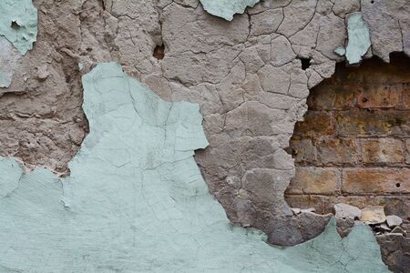 Close-up of cracked paint and fallen plaster.