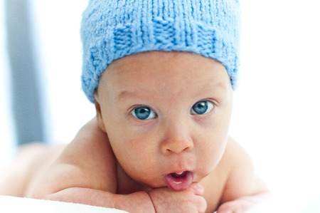 A child with blue eyes in the hat. Big Blue eyes. Cute Blue Eyes Baby. Eyes full of happiness. Happy baby eyes.の写真素材