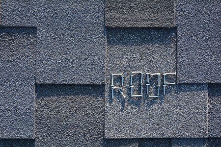 Close up view on Asphalt Roofing Shingles Background. Roof Shingles - Roofing. Asphalt Roofing Shingles and Nails are laid out in the form of the word Roof.の写真素材