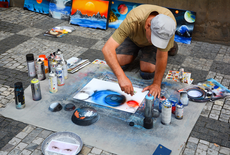 PRAGUE, CZECH REPUBLIC - JULY 17, 2017: A man paints pictures on the street, using paint spray cans of different colors.のeditorial素材