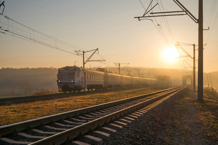 Passenger train on the railway bridge in autumn foggy morning.のeditorial素材