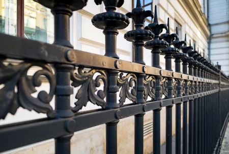 Beautiful decorative cast metal wrought fence with artistic forging. Iron guardrail close up.の写真素材