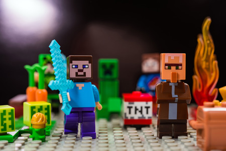 Kiev, Ukraine - January 30, 2019: Minifigure Steve with diamond sword and villager run away from the Creeper. Characters of the game Minecraft.のeditorial素材