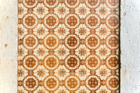 Old wall with traditional Portuguese decor tiles azulezhu in brown tones.