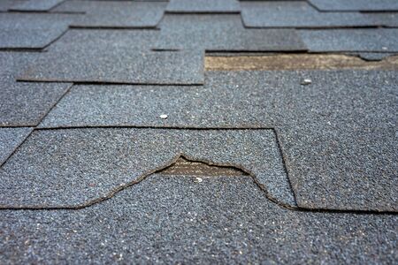 ?lose up view of bitumen shingles roof damage that needs repair.の写真素材