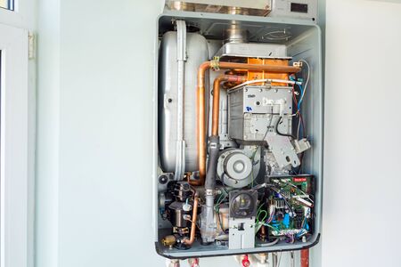 Kiev, Ukraine - October 03, 2019: View of the disassembled gas water heater boiler for home heating. Installation, connection and maintenance concept.のeditorial素材