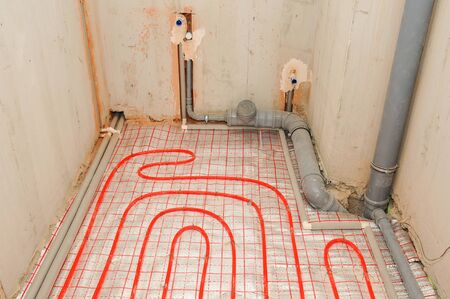 Installation water underfloor heating pipes on the silver reflective material in house construction.の写真素材
