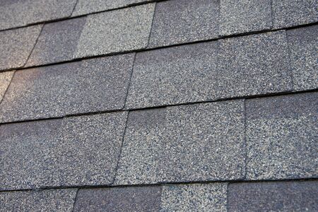 Close up view on asphalt roofing shingles background.
