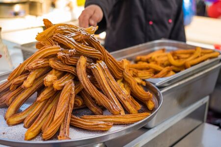 Churros sticks deep fried and dusted with powdered sugar. Sweet street food.の写真素材
