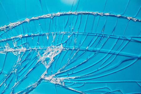 Blue background through the broken window glass.の写真素材