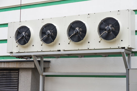 Close-up of an industrial air conditioner compressor outdoor unit mounted on a bracket.の写真素材