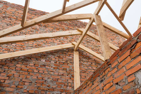 Installation of wooden beams at construction the roof truss system of the house.の写真素材
