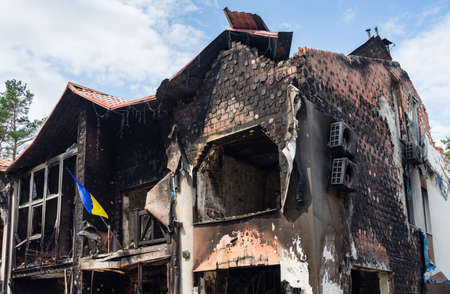 House with Ukrainian flag destroyed by russian army in the suburbs of Kyiv (Irpin). russia's war against Ukraine.の写真素材
