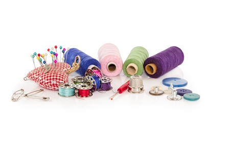 collection of sewing tools and supplies in a sewing kit on a white backgroundの写真素材