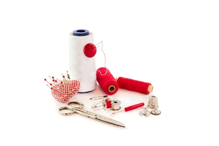 collection of sewing tools and supplies in a sewing kit on whiteの写真素材