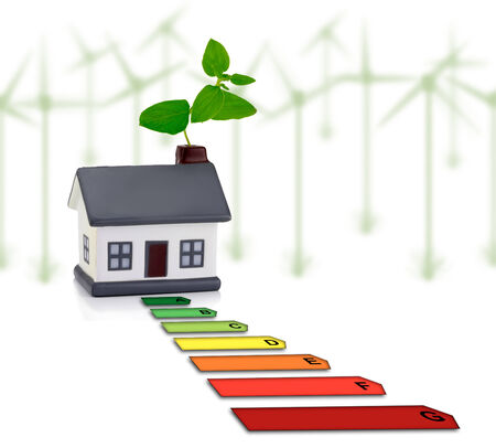 House and energy saving, energy efficiency in the home with windmill in backgroundの写真素材