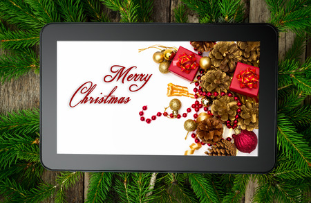Christmas tablet on tree brunchの写真素材