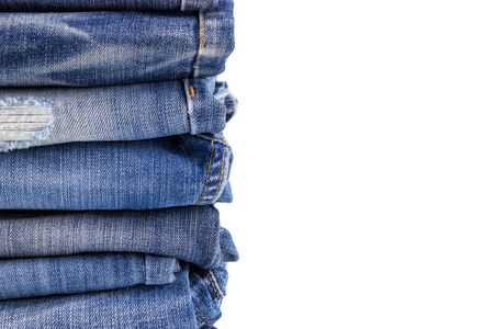 Close up of denim jeans stack collected together isolated over white backgroundの写真素材