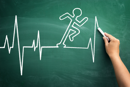 Conceptual cardiogram chart heartbeat with shape of man race, hand drawing sketch on chalkboardの写真素材