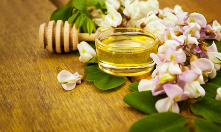 honey with acacia blossoms on wooden tableの写真素材