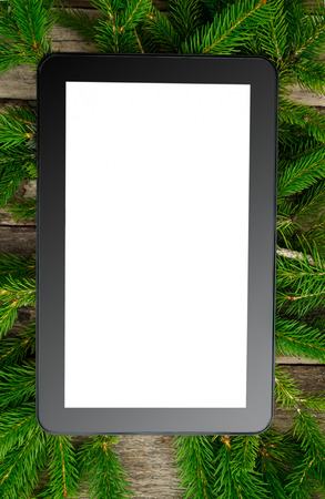 Tablet with empty screen on Christmas tree brunchの写真素材