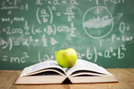 Education concept, book and apple in the background of the blackboardの写真素材
