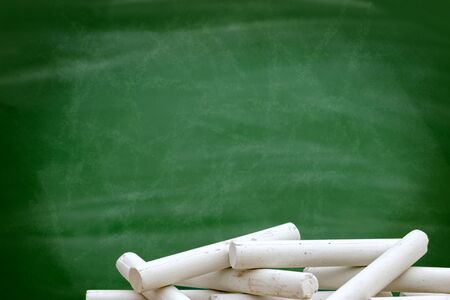 Pile of white chalk front of blackboard green,  empty blank with copy space for chalk textの写真素材