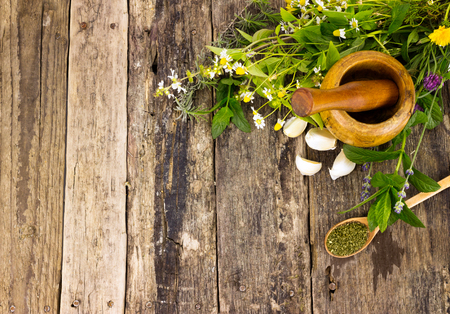 fresh flavoring herbs,  spices and mortar on wooden table, top viewの写真素材