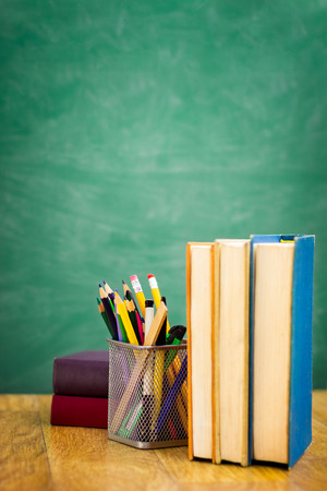 School textbooks on a desk in front of empty  blackboardの写真素材