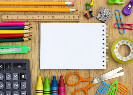 school supplies and checked notebook on wood backgroundの写真素材