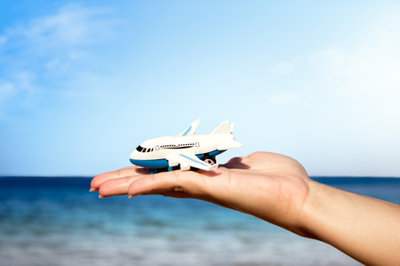 model airplanes in the palm on the background of the sea, concept holiday travelingの写真素材