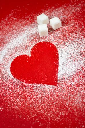 Heart made of sugar on red backgroundの写真素材